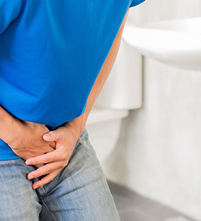 Hombre con dolor en la zona abdominal en el baño